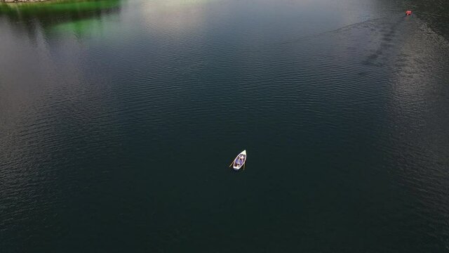 Drone circling around a rowboat on a beautiful lake, landscape, cute couple, love, lovers,  relax, nature, dinghy, tourism, vacation, holiday, aerial drone shot, Slow Motion