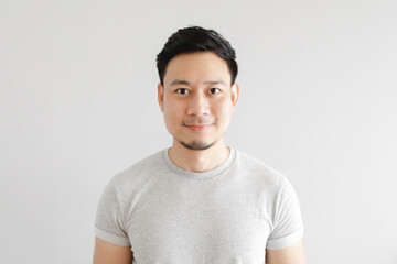 Obraz premium Smile face of happy Asian man wear grey t-shirt and on grey background.