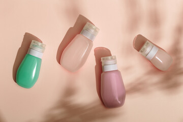Cosmetic bottles for cream, gel, lotion. Beauty product package, mock up plastic container with hard shadows on beige