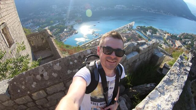 Man taking selfie at Fortifications of Kotor, fortress of St. John, Montenegro