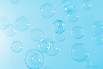 Fototapeta na wymiar Beautiful shiny transparent soap bubbles float on blue texture background. Abstract, Celebration, Natual fresh summer, Chrimas holiday background.