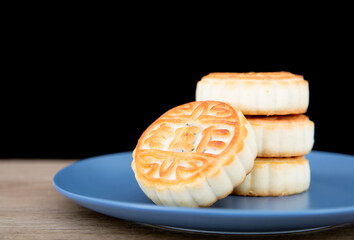 A plate of moon cakes for the Chinese Mid-Autumn Festival on the table in front of black background