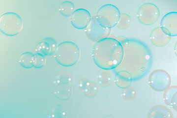 Abstract, Beautiful transparent soap bubbles float on soft green background. Natural freshness summer background.
