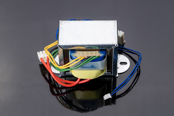 radio electric transformer isolated on dark background. electrical component industry concept