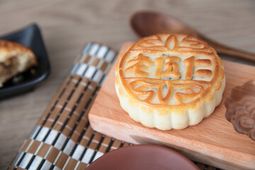 A piece of moon cake placed on a wooden moon cake mold