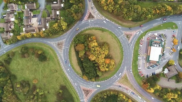 High angle rotation above urban grass roundabout junction traffic