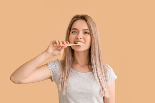 Young woman with tooth brush on color background
