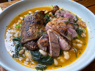 Duck Duo, pan fried duck breast, confit duck leg, creamy white beans, crispy bacon, asparagus & spinach
