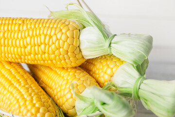 Fresh corn cobs in basket, closeup