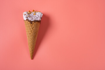 top view sweet potato flavor ice cream cone with a bite on a pink background