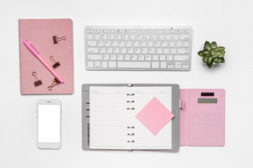Stationery with computer keyboard and mobile phone on white background