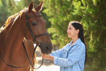 Fototapeta premium Beautiful young woman with cute horse outdoors
