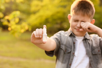 Little allergic boy with remedy outdoors