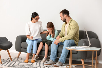Obraz premium Child therapy session, crying girl receiving emotional support from therapist and father