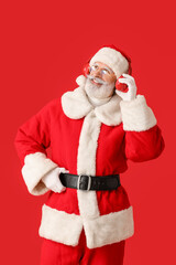 Cool Santa Claus listening to music on color background