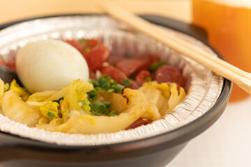 clay pot rice of Chinese style sausage and salty duck egg and vegetable with cup of lemon tea on background horizontal composition
