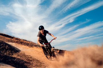 Naklejka na ściany i meble mountain biker on a dusty road