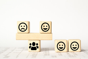 Close up custome choose smiley and sad face icon on wood cube, Service rating, satisfaction concept.