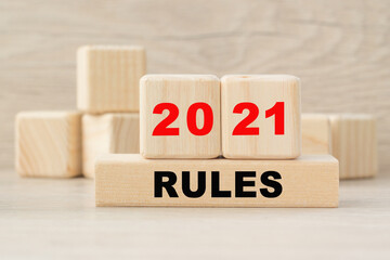 the word 2021 RULES is written on a wooden cubes structure. Cube on a bright background. Can be used for business, marketing, financial concept. Selective focus.