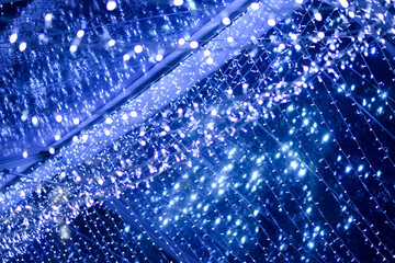 Naklejka premium Blue LED flashing, blinking bulbs. Christmas illumination lights on the ceiling and walls.