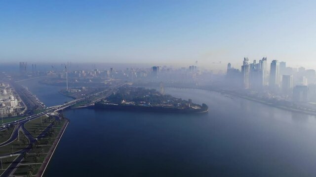 View from above of Sharjah's Khalid Lake, Eye of Emirates, Sharjah Skyline on a foggy morning, Fog in Gulf, United Arab Emirates, 4K video