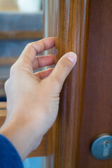 Hand on opening a wooden door