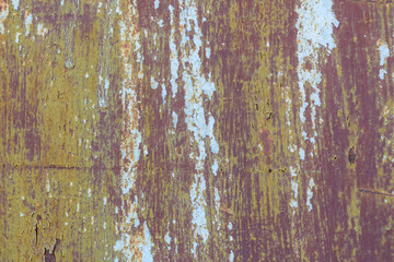 Old multicolor paint on surface for the backdrop. The color is white, green, brown. Vertical stripes.