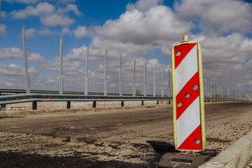Red and white road sign. The road guidance barrier is on the road