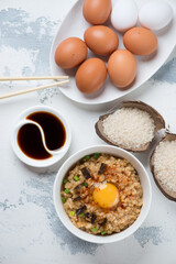 Japanese-style rice and egg bowl, vertical shot on a white concrete background, view from above