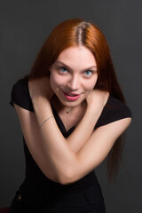 portrait of a beautiful red haired young positive woman in studio
