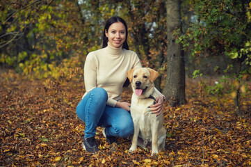 Young woman with a dog on a walk in the autumn Park