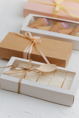 Windowed and sealed ribbon tied boxes with sweets. On white surface.