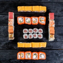 A set of several types of sushi rolls with fish.  Japanese fast food.