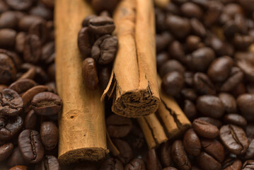 Cinnamon sticks on coffee beans blur background. Close up.