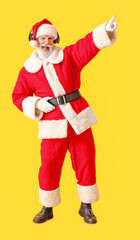 Cool Santa Claus listening to music on color background