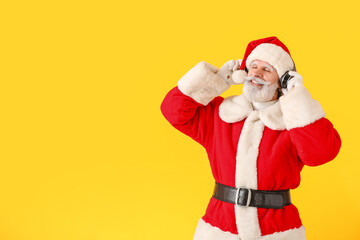 Fototapeta na wymiar Cool Santa Claus listening to music on color background