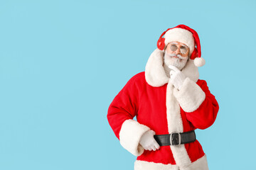 Cool Santa Claus listening to music on color background