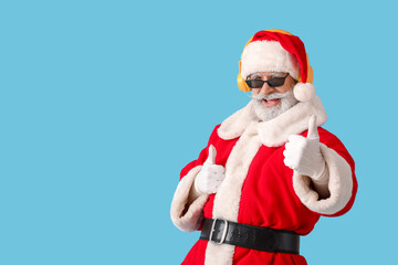 Cool Santa Claus listening to music on color background