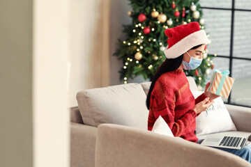 Young woman celebrating Christmas at home due to coronavirus epidemic