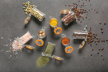 Obraz na płótnie Canvas Jars with different spices on dark background