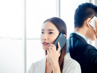 Business Asian couple using mobile phone.