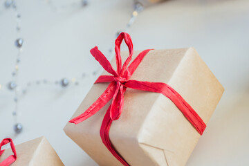 Gift boxes made from craft paper with red ribbon on white background - 392786520