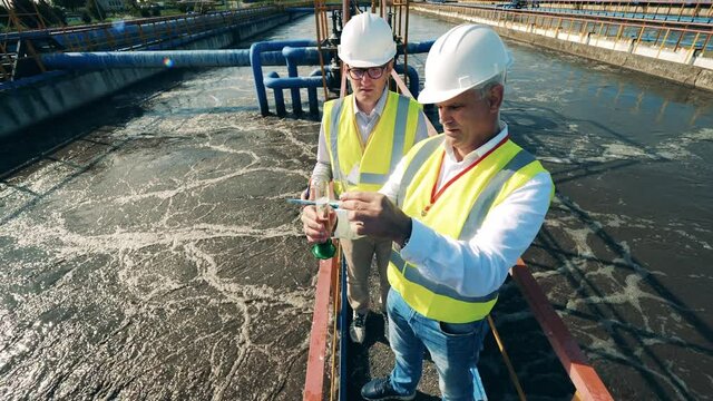Inspectors are analyzing a water sample at the sewage cleaning site