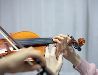 helping the teacher to keep his hand on the violin correctly, placing children's hands when playing...