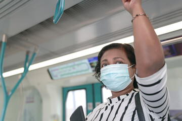 Obraz na płótnie Canvas Woman commuter wearing face mask inside train