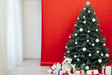 Fototapeta premium New Year's card interior red decor and Christmas tree with gifts