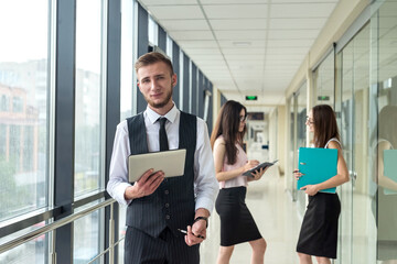 Three beautiful business partners discussing paperwork in modern .office hallway