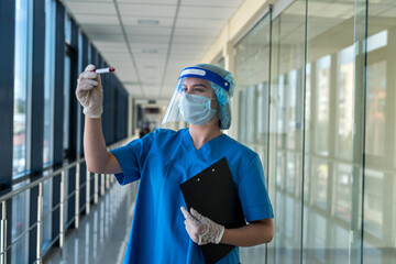 female student looks at a test tube of blood in the laboratory to determine virus coronavirus