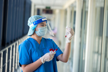 nurse wearing face shield uniform holding positive blood test result for COVID-19