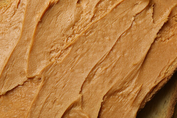 Toast with peanut butter on whole background, close up